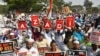 Para pengunjuk rasa muslim memegang spanduk dan mengibarkan bendera India selama demonstrasi menentang UU Kewarganegaraan baru India di Bangalore pada 3 Januari 2020. (Foto: AFP)