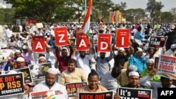 Muslim protesters hold placards and wave Indian flags during a protest rally against India's new citizenship law in Bangalore on January 3, 2020. 