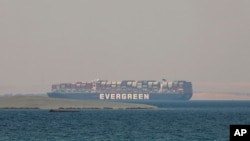 FILE - The Ever Given, a cargo vessel operated by shipping company Evergreen, is seen anchored in Egypt's Great Bitter Lake, March 30, 2021, after blocking the Suez Canal earlier in March. 