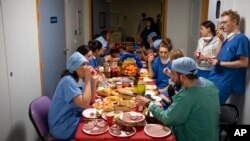 Doctors and nurses share a Christmas Eve meal together in the COVID-19 intensive care unit at la Timone hospital in Marseille, southern France, Dec. 24, 2021.