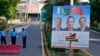 Police officers stand guard next to a welcome billboard with portraits of China's Premier Li Qiang, center, Pakistan's Prime Minister Shehbaz Sharif and President Asif Ali Zardari, ahead of the Shanghai Cooperation Organization summit in Islamabad, Pakistan, Oct. 13, 2024.