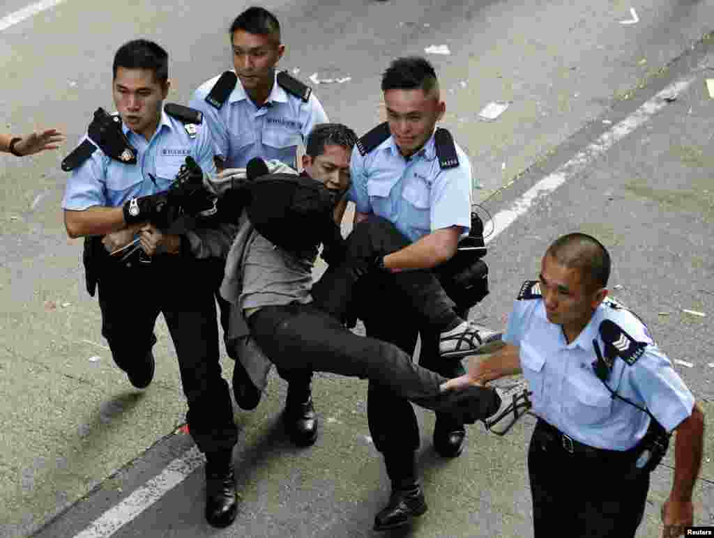 A pro-democracy protester is arrested after refusing to leave the protest site being dismantled by bailiffs under a court injunction, at Mong Kok shopping district in Hong Kong, Nov. 25, 2014.