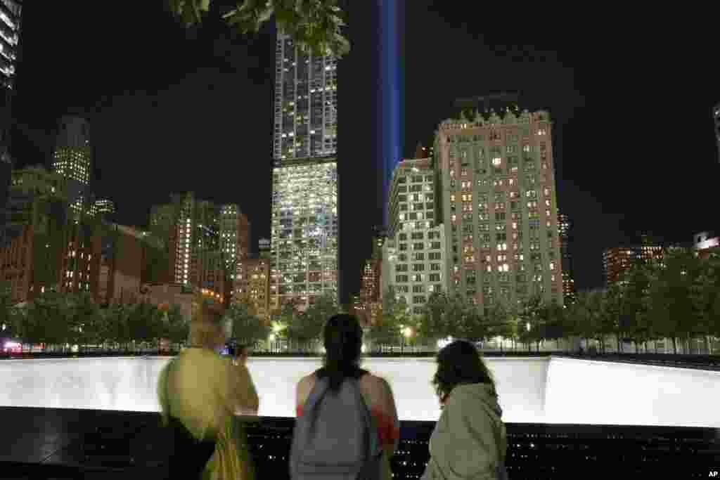 Visitors to the National September 11 Memorial observe the Tribute in Light, New York, Sept. 8, 2014.