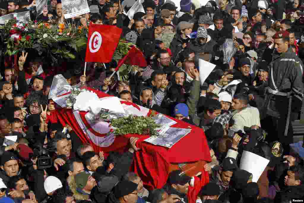 Mourners carry the coffin of slain opposition leader Chokri Belaid during his funeral procession towards El-Jellaz cemetary, Tunis, Feb. 8, 2013. 