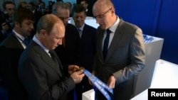Russia's President Vladimir Putin (front L), International Olympic Committee (IOC) President Jacques Rogge (C) and head of the Sochi 2014 Organising Committee Dmitry Chernyshenko (front R) visit the stand displaying medals for the 2014 Winter Olympic Game