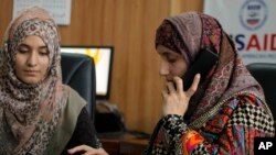 Seorang pengacara Pakistan Shandana Naeem, kanan, sedang menelepon bersama rekannya Nayab Hassan di kantor mereka di Peshawar, 28 Maret 2017. (Foto: AP)