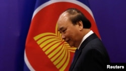 FILE - Vietnam's Prime Minister Nguyen Xuan Phuc walks past the ASEAN flag as he attends an event as part of the 37th ASEAN Summit in Hanoi, Vietnam, November 15, 2020. 