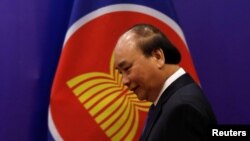 FILE - Vietnam's Prime Minister Nguyen Xuan Phuc walks past the ASEAN flag as he attends an event as part of the 37th ASEAN Summit in Hanoi, Vietnam, Nov. 15, 2020. 