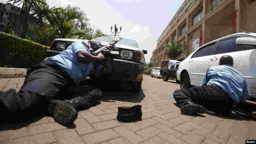 Polisi wajificha ili kujikinga kutokana na shambulio la bunduki katika soko la Westgate ambako washambuliaji wenye bunduki walishambulia na kuchukua baadhi ya wateja mateka mjini Nairobi Septemb 21, 2013.