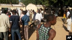 Curiosos observan el sitio de la explosión en el Government Science Technical College de Postikim, Nigeria, donde murieron unos 48 estudiantes.
