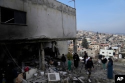 Residents inspect the location of the Israeli airstrike that killed six Palestinians on Wednesday, in the West Bank refugee camp of Jenin, Jan. 16, 2025.