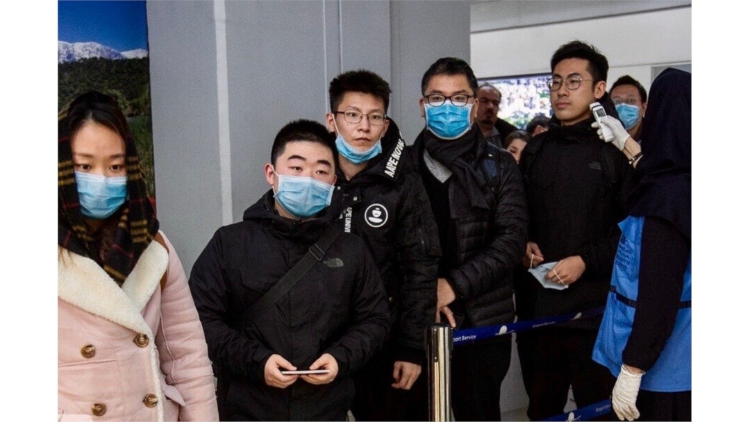Chinese travelers wearing face masks to protest against the coronavirus undergo a health screening upon arrival at Tehran's Imam Khomeini Airport in this undated photo published by IRNA on Jan. 30, 2020.