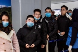 Chinese travelers wearing face masks to protest against the coronavirus undergo a health screening upon arrival at Tehran's Imam Khomeini Airport in this undated photo published by IRNA on Jan. 30, 2020.