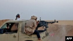 FILE - A combatant mans a heavy machine gun as forces loyal to Yemen's Saudi-backed government clash with Houthi rebel fighters, in the al-Jadaan area about 50 kilometers northwest of Marib, in central Yemen, Nov. 22, 2020.