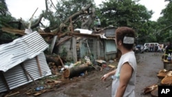 Beberapa rumah warga di kota Quezon, utara ibukota Manila, rusak tertimpa pohon yang roboh akibat topan Koppu yang melanda Filipina, Senin (19/10). 