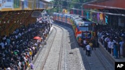 Sri Lankan ethnic Tamils gather on platforms and welcome the train "Queen of Jaffna," as it arrives at Jaffna, Oct. 13, 2014.
