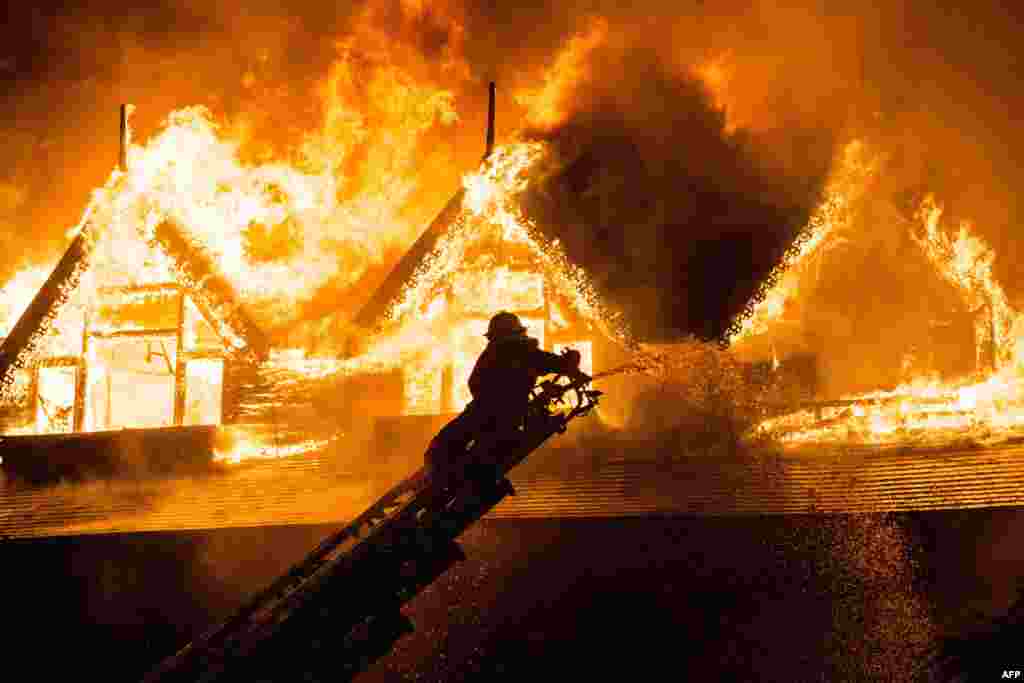 A firefighter extinguishes a fire at Kandawgyi Palace hotel in Yangon, Myanmar. One person died in a pre-dawn blaze that tore through a teakwood hotel popular with foreign visitors to the country&#39;s main city.