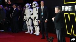 Carrie Fisher poses for photographers with a dog upon arrival at the European premiere of the film 'Star Wars: The Force Awakens' in London, Dec. 16, 2015. (Photo by Joel Ryan/Invision/AP)