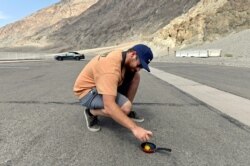 Un hombre intenta cocinar un huevo en el pavimento caliente en Valle de la Muerte, en California.