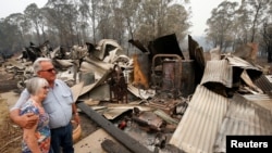 Lyn and Peter Iverson with their burnt out office and shed on their property at Half Chain road, Koorainghat, Australia, November 11, 2019.