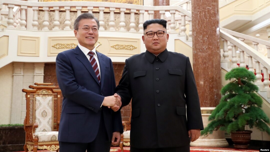 Presiden Korea Selatan, Moon Jae-in berjabat tangan dengan Pemimpin Korea UTara, Kim JOng-un di Pyongyang, Korea Utara, 18 September 2018. 