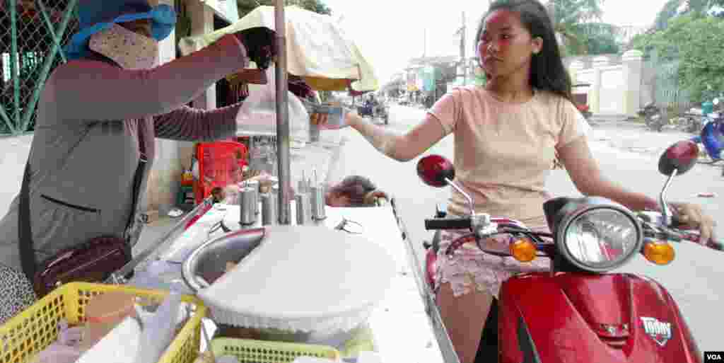 ស្រ្តីជនជាតិវៀតណាមម្នាក់ (មិនមែនមានន័យថាខុសច្បាប់ទេ) ប្រកបរបររកស៊ីលក់បង្អែមនៅសង្កាត់ព្រែកប្រា ខណ្ឌច្បារអំពៅ រាជធានីភ្នំពេញ នៅថ្ងៃសុក្រ ទី១៩ ខែសីហា ឆ្នាំ២០១៦។(ឡេង ឡែន/VOA)