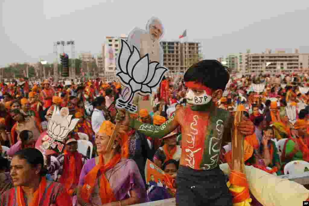 An Indian child with his body painted holds a cut out of Indian Prime Minister Narendra Modi with a symbol of the Bharatiya Janata Party (BJP) during an election campaign rally in Ahmadabad, India.