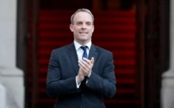 Britain's foreign secretary, Dominic Raab, applauds at the Foreign Office in London during the weekly "Clap for our Carers" in London, April 23, 2020.