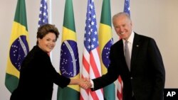 La presidenta de Brasil, Dilma Rousseff, saluda al vicepresidente Joe Biden en el palacio presidencial de Planalto, Brasilia.