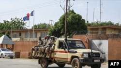 Une patrouille de la Police nationale nigérienne passe devant l'ambassade de France à Niamey, le 28 août 2023.