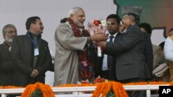 Indian Prime Minister Narendra Modi, center, is given flowers as he arrives for a campaign rally ahead of local elections in Srinagar, in Indian-controlled Kashmir, Dec. 8, 2014. 