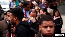 A man rubs his eyes as he waits in a line of jobseekers, to attend the Dr. Martin Luther King Jr. career fair held by the New York State department of Labor in New York, April 12, 2012. 