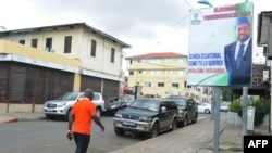 Un homme passe devant une affiche électorale du parti d'opposition PCSD-Baboro de la coalition social-démocrate à Malabo le 23 avril 2016.