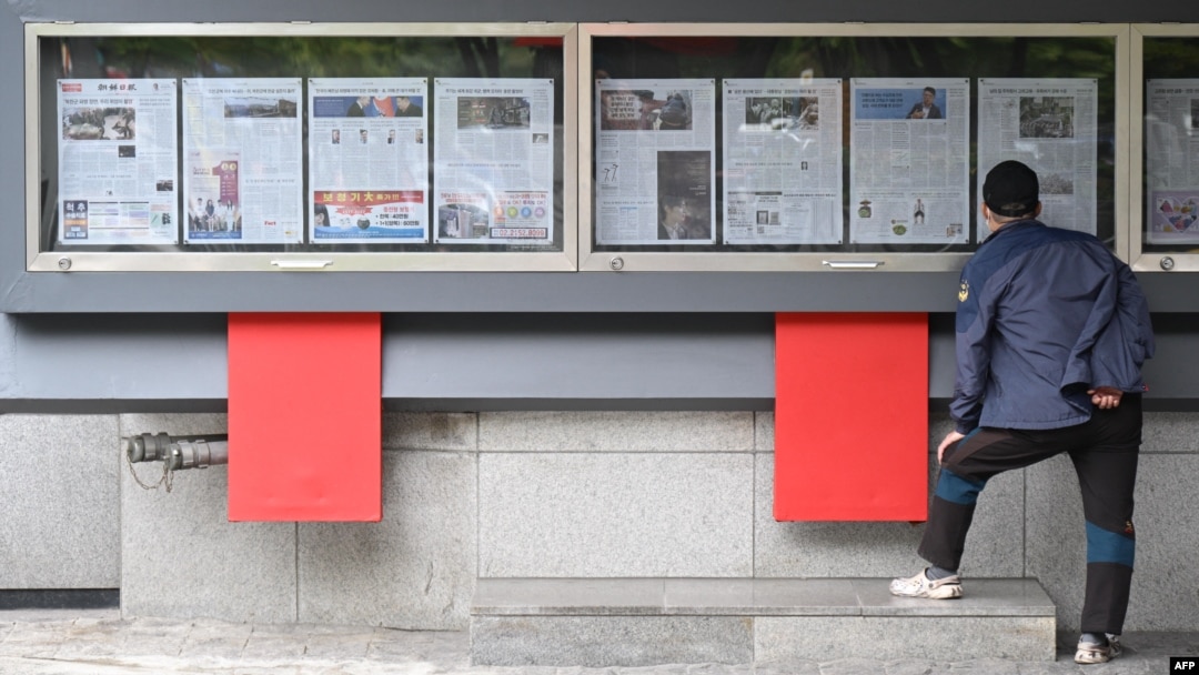 Čovjek čita novine istaknute na ulici u Seulu 21. oktobra 2024. Neke od stranica sadrže navode da je Sjeverna Koreja odlučila da rasporedi hiljade vojnika za Rusiju na ukrajinskim linijama fronta.