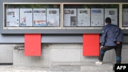 A man reads a newspaper displayed on a street in Seoul on Oct. 21, 2024. Some of the pages contain coverage of allegations that North Korea has decided to deploy thousands of soldiers for Russia on Ukraine's front lines.