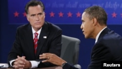U.S. President Barack Obama speaks as Republican presidential nominee Mitt Romney listens during the final U.S. presidential debate in Boca Raton, Florida, October 22, 2012. 