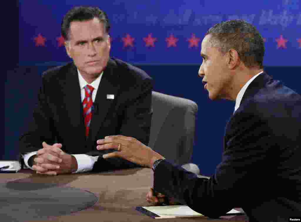 U.S. President Barack Obama speaks as Republican presidential nominee Mitt Romney listens during the final U.S. presidential debate in Boca Raton, Florida, October 22, 2012. 