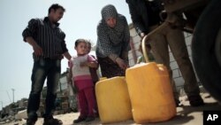 Une famille palestinienne achète de l'eau potable remplit d'eau potable dans le camp de réfugiés de Khan Younes, au sud de la bande de Gaza.