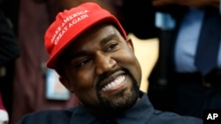 Rapper Kanye West smiles as he listens to a question from a reporter during a meeting in the Oval Office of the White House with President Donald Trump, Oct. 11, 2018, in Washington. 