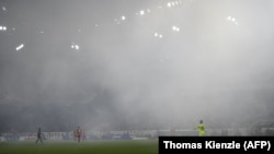 Kiper Freiburg dari Belanda, Mark Flekken berdiri di lapangan yang diselimuti asap di stadion dalam laga divisi satu Jerman Bundesliga antara SC Freiburg dan VfL Wolfsburg di Freiburg, 19 Mei 2023. (Foto: Thomas Kienzle/AFP)