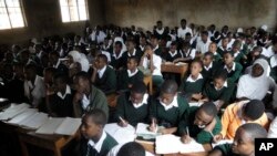 FILE - Students work shoulder-to-shoulder at a secondary school near Moshi, Tanzania, July 29, 2010.