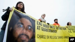 FILE - Human rights activists hold a banner with a picture of Shaker Aamer.