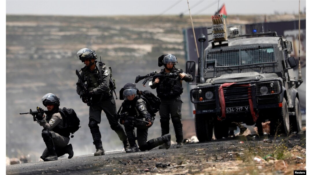 Israeli border police officers take up position during a Palestinian protest marking the 70th anniversary of Nakba, near the Jewish settlement of Beit El, near Ramallah, in the occupied West Bank, May 15, 2018.