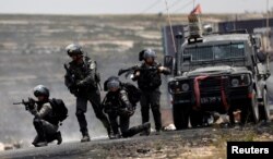 Israeli border police officers take up position during a Palestinian protest marking the 70th anniversary of Nakba, near the Jewish settlement of Beit El, near Ramallah, in the occupied West Bank, May 15, 2018.