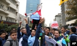 Iranian schoolboys chant slogans while holding an effigy of U.S. President Donald Trump in an annual gathering in front of the former U.S. Embassy marking the anniversary of its 1979 takeover, in Tehran, Iran, Nov. 4, 2017.