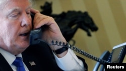 FILE - U.S. President Donald Trump speaks by phone with Russia's President Vladimir Putin in the Oval Office at the White House in Washington, Jan. 28, 2017. 