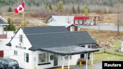 FILE - Ouellete's Gaz Bar, background, sits in Estcourt Station, Maine, 150 feet from the U.S. border with Canada at the town of Pohenegamook, Quebec.