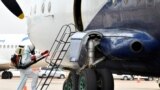 FILE - A member of a medical team wearing a protective suit cleans the staircase to a plane to prevent the spread of the coronavirus disease at the Juba International Airport in Juba, South Sudan, April 5, 2020.