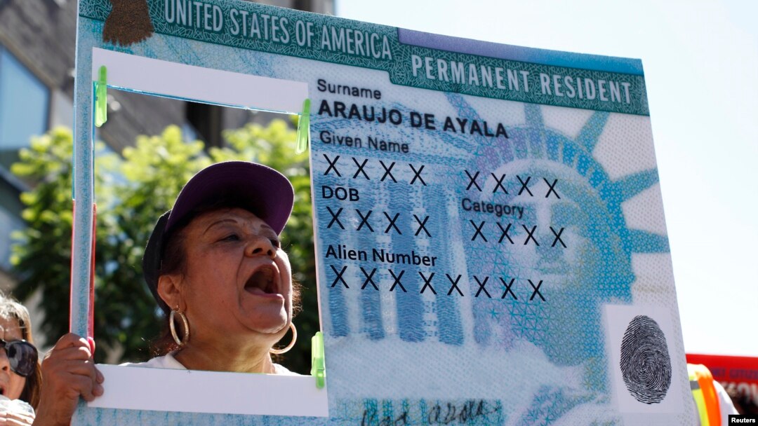 Seorang perempuan memegang replika green card (kartu penduduk tetap AS) dalam aksi menuntut reformasi imigrasi di Hollywood, Los Angeles, AS (foto: dok). 