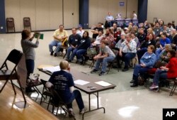 FILE - Voters listen to instructions during a Democratic party caucus in Nevada, Iowa, Feb. 1, 2016.